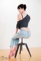 Sitting on stool wearing jeans bare feet