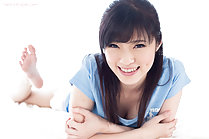 Yurikawa Sara lying on her front arms folded under her chest soles of her bare feet raised