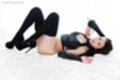 Lying on her back knees drawn up in black boots