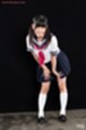 Kogal in uniform hair in pigtails leaning forward hands on her knees