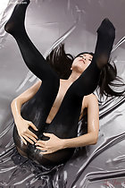 Spreading her pussy in black pantyhose legs raised long hair splayed out on sheet