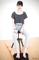Sitting on stool wearing jeans teasing with bare feet