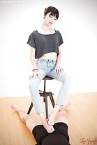 Seated on stool wearing jeans giving footjob bare feet