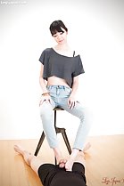 Matsuda Anna seated on stool hands on her thighs giving footjob bare feet