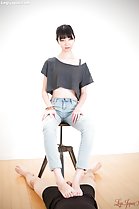 Sitting on stool wearing jeans cock between her bare feet
