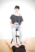 Stroking cock with her bare feet sitting on stool