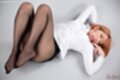 Lying on her back knees drawn up in pantyhose