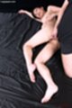 Lying on her side naked man cumming on her thigh bare feet