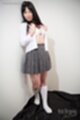 Standing against wall in uniform opening shirt exposing bra wearing plaid skirt white socks