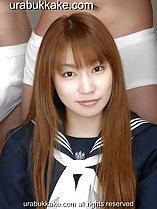 Saya seated before men in underwear long hair over her shoulders